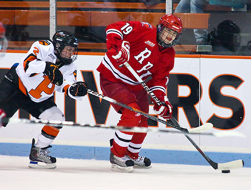 Jordan Smelker (RPI - 19) plays the puck along the boards as Kelly Cooke (Princeton - 2) gives chase. Rensselaer visited Princeton's Hobey baker rink, falling to the Princeton Tigers 4-2. (Shelley M. Szwast)